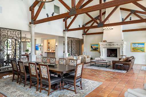 A large room with a fireplace and a dining table.