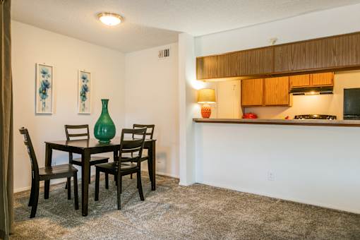 A dining room with a table and chairs.