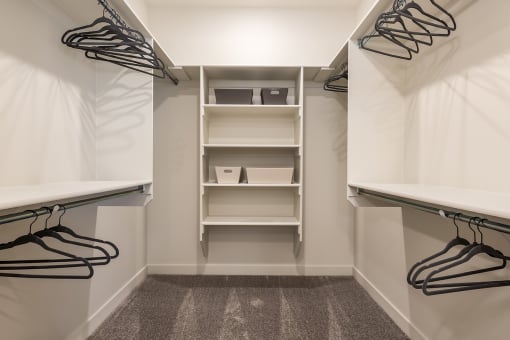 a walk in closet with shoe racks and a curtain