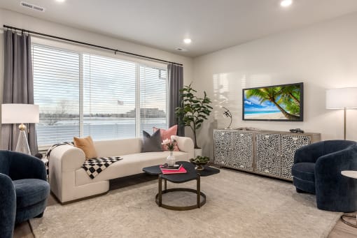 a living room with a view of the water and a couch and chairs