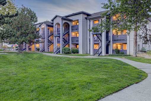 A large apartment complex with a green lawn in front.