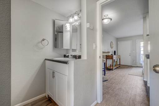 A white bathroom with a vanity and mirror.