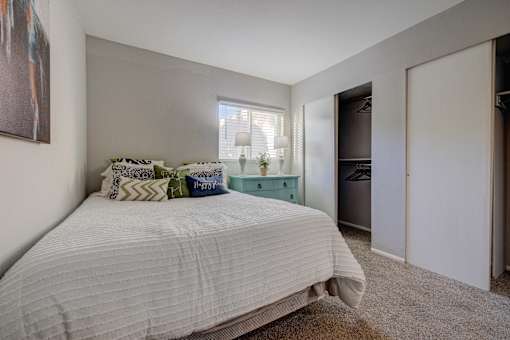 A bedroom with a large bed and a painting on the wall.