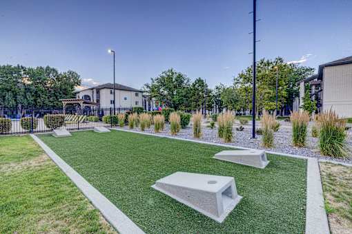 A playground with artificial grass and concrete structures.
