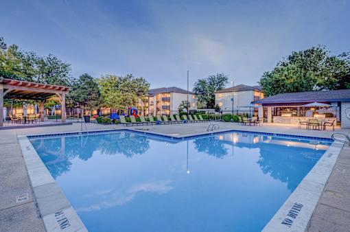 A large swimming pool with a reflection of the sky and trees.
