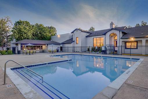 A large house with a pool in front.