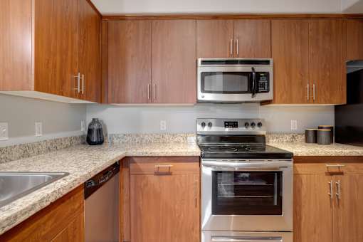 A kitchen with wooden cabinets and a stainless steel oven.
