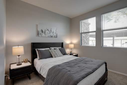 A bedroom with a large bed and a painting on the wall.