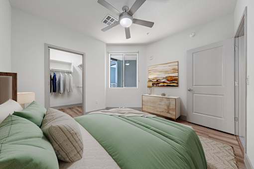 A bedroom with a bed, pillows, a dresser, and a painting on the wall.
