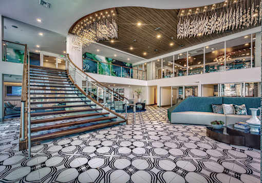 A large, open-concept living space with a staircase and a patterned floor.