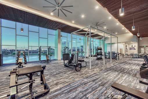 A gym with wooden floors and a variety of exercise equipment.