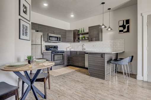 A modern kitchen with a dining table and chairs.