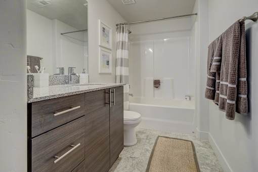 A bathroom with a toilet, sink, and shower.