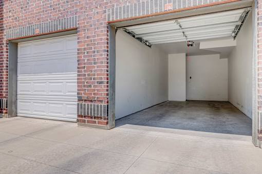 A garage door is closed and the garage is empty.