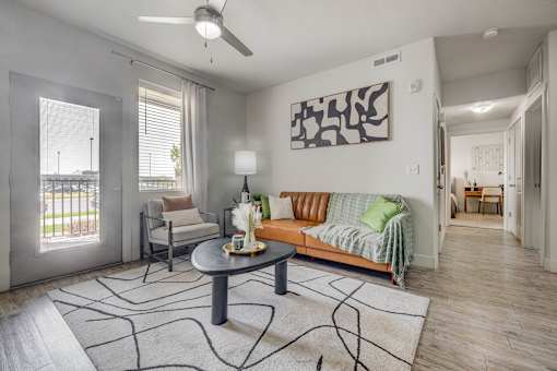 A living room with a grey sofa, a coffee table, and a painting on the wall.