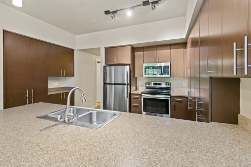 a kitchen with wood cabinets and a granite counter top at Allez, Redmond, 98052