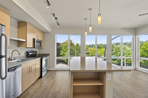 a kitchen with a large island and a view of the trees outside at Allez, Washington