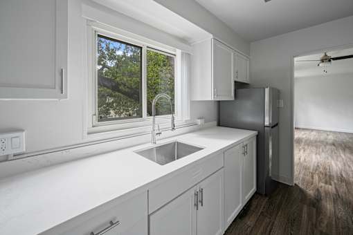 A modern kitchen with white cabinets and a window at Hillsdale Garden Apartments, San Mateo