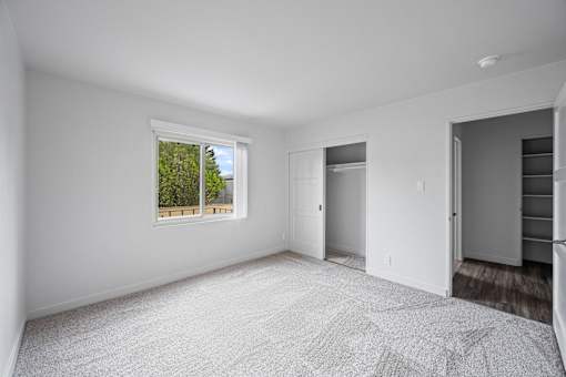A spacious, empty room with a window and a door at Hillsdale Garden Apartments, CA 94403