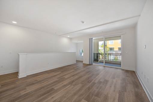 A spacious living room with large patio doors at Palomar Station apartments in San Marcos, CA.