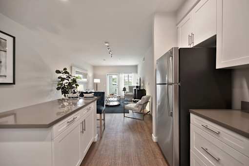 A modern kitchen with white cabinets and a black refrigerator.