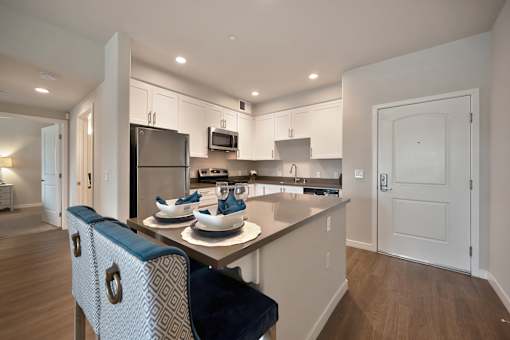 A modern kitchen with a dining table and chairs.