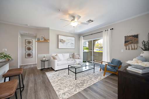 A living room with a white couch, a coffee table, and a ceiling fan.