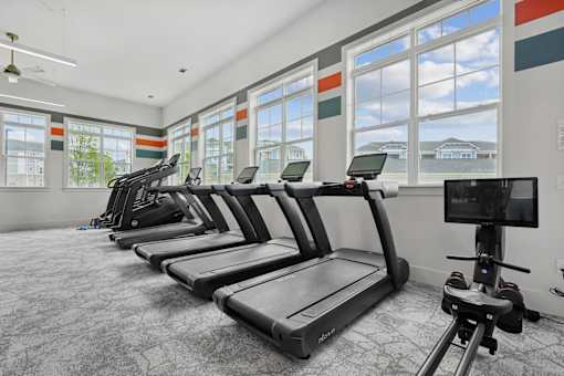 A gym with treadmills and a television.