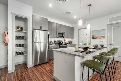 A modern kitchen with a wooden floor and white walls.