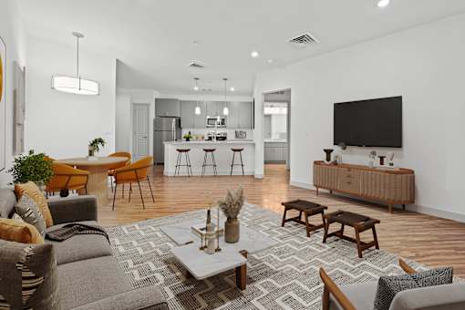 A modern living room with a grey sofa, wooden coffee table, and a television.