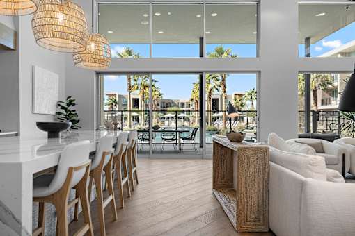 A modern living room with a dining area and a view of the outdoors.