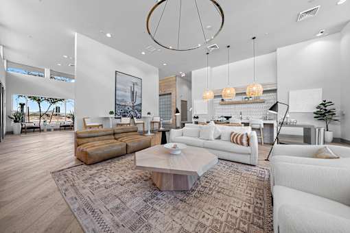 A modern living room with a white sofa set and a wooden coffee table.