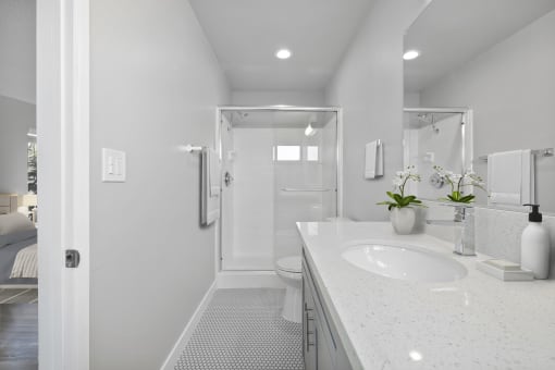a white bathroom with a sink and a shower at The Fulton, Los Angeles