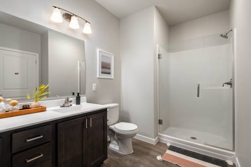A bathroom with a toilet, sink, and shower.