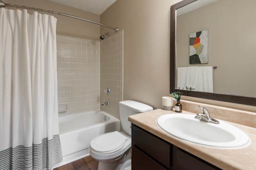 A bathroom with a toilet, sink, and shower.