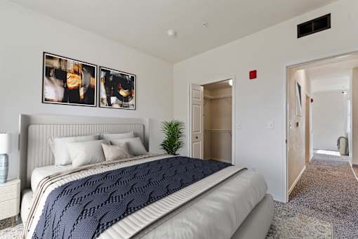 A bedroom with a large bed and a carpeted floor.