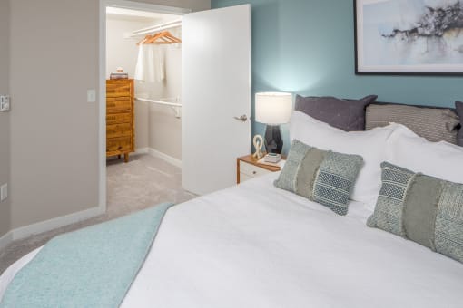 a bedroom with a large bed and a bathroom in the background