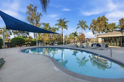 A large outdoor swimming pool with a blue tarp over the seating area.