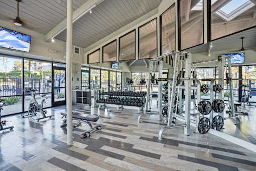 A gym with a variety of equipment including weights and exercise machines.