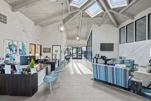 A spacious office with a skylight and a reception desk.