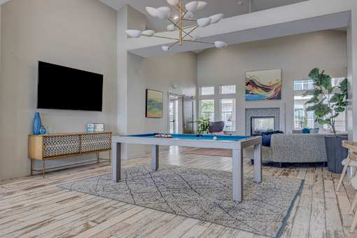A modern living room with a pool table and a television.