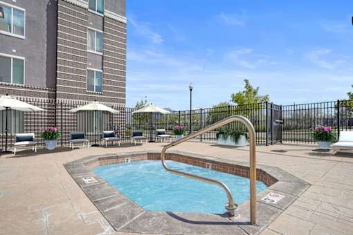 A small pool with a slide in the middle of a patio.