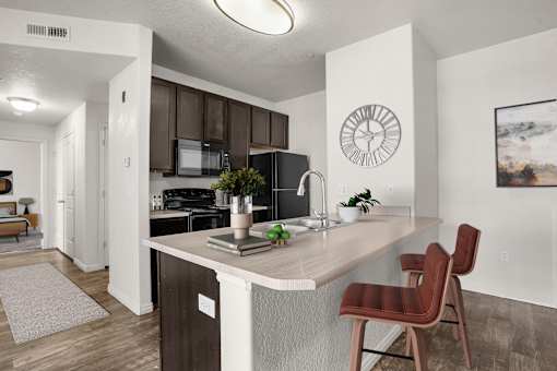 A kitchen with a brown chair and a white counter.