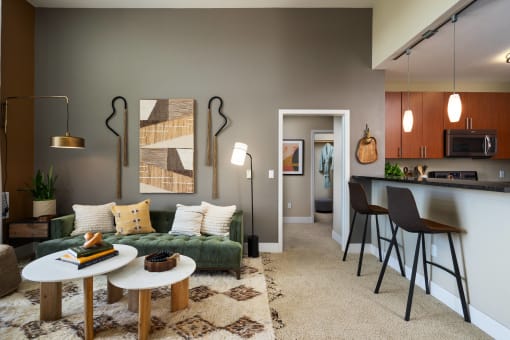 a living room with a couch and a kitchen with a bar