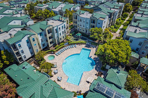 An aerial view of apartment buildings surrounding a swimming pool.