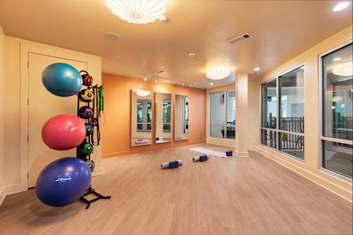 A room with exercise equipment and a yoga mat.