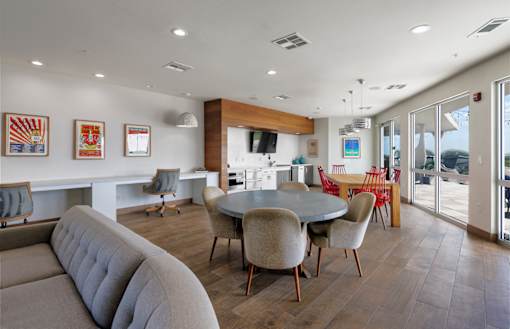 A modern living room with a grey sofa and a round table with chairs.