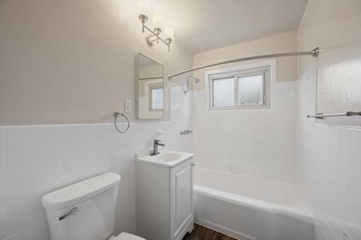 A white bathroom with a tub, toilet, and sinkat Hillsdale Garden Apartments, San Mateo