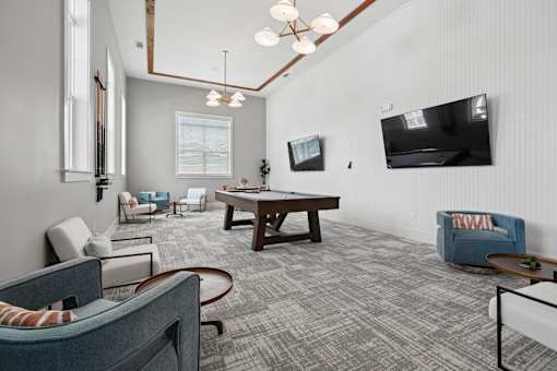 A living room with a grey carpet and a wooden table.