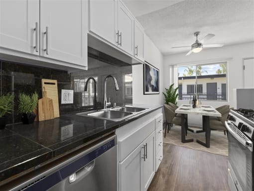 a kitchen with white cabinets and a black counter top at Pacific Rose, Los Angeles
